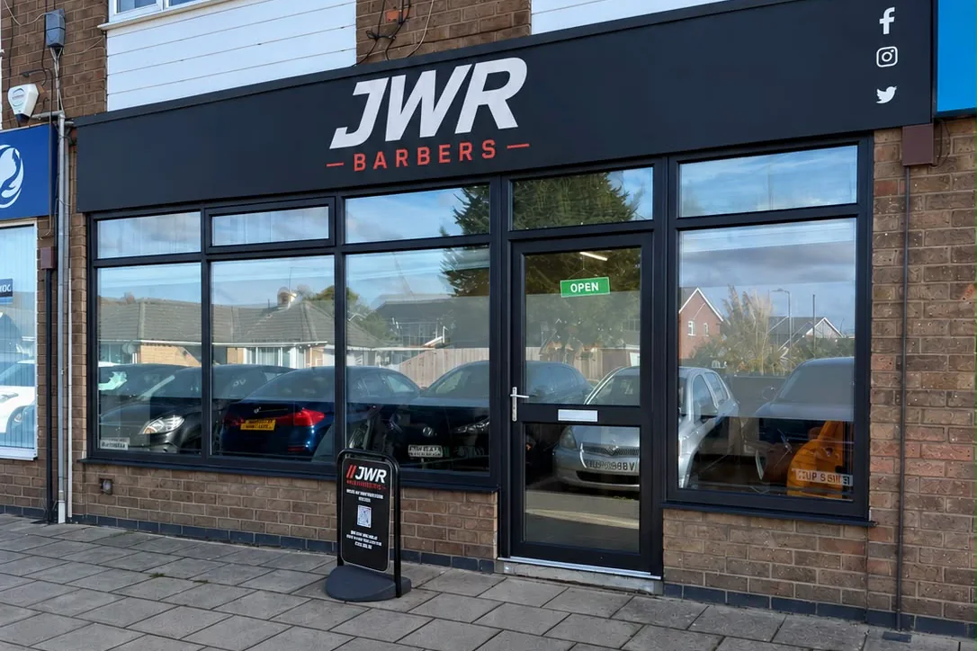 The JWR Barbers shopfront on Redwood Drive, Waddington — black fascia, full-width window, open sign on the door